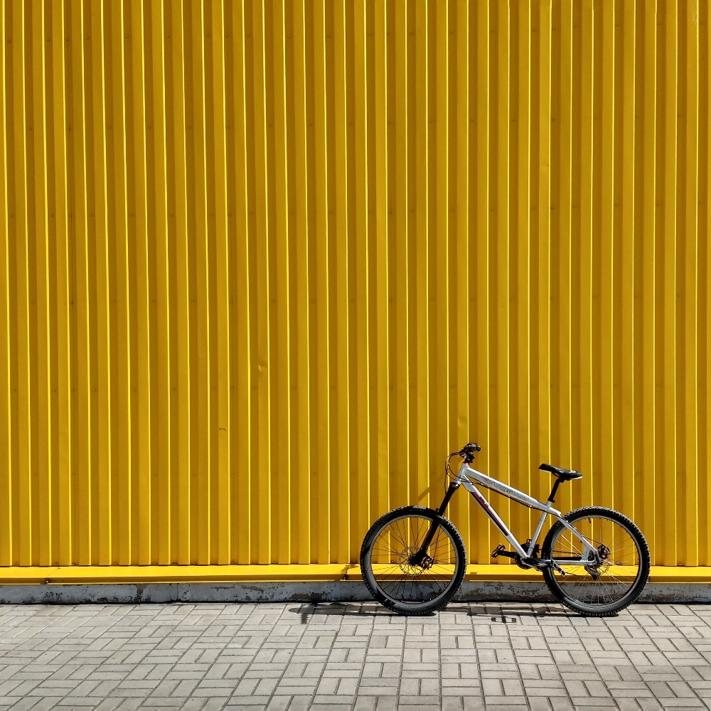 Bike propped up outdoors in front of a yellow corrugated background